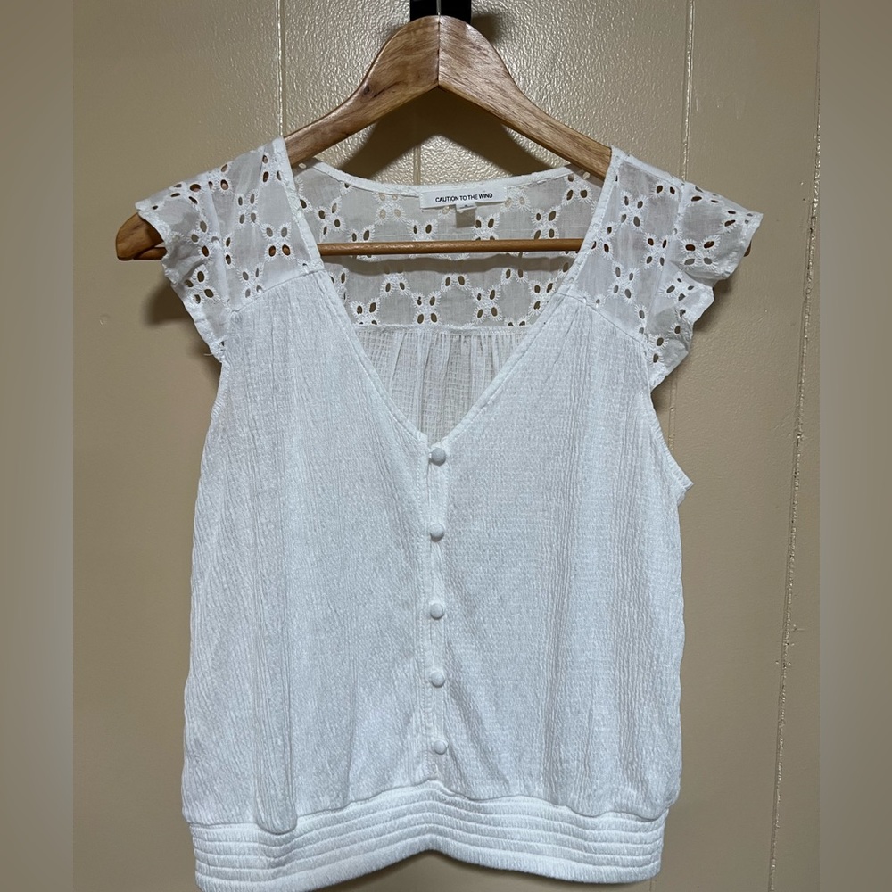 Adorable white top with eyelet sleeves.